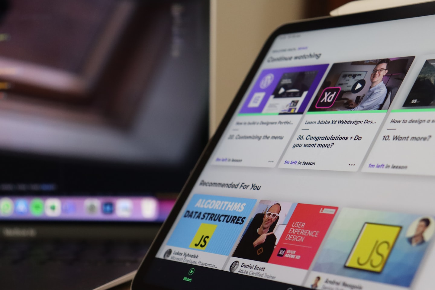 A tablet displays an online learning platform with course thumbnails.